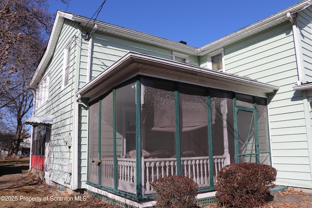 view of home's exterior with a sunroom