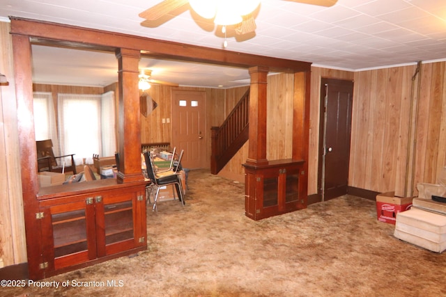 interior space featuring ceiling fan and wood walls