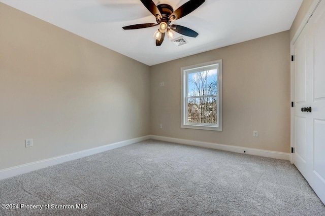 spare room with ceiling fan, carpet, visible vents, and baseboards