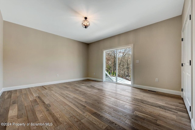 unfurnished room with visible vents, baseboards, and wood finished floors