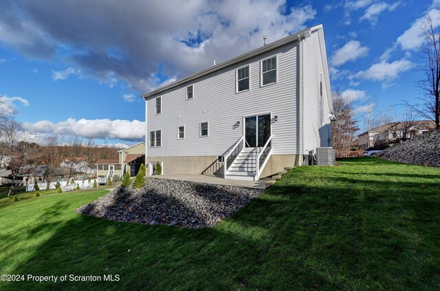 back of house featuring central AC and a yard