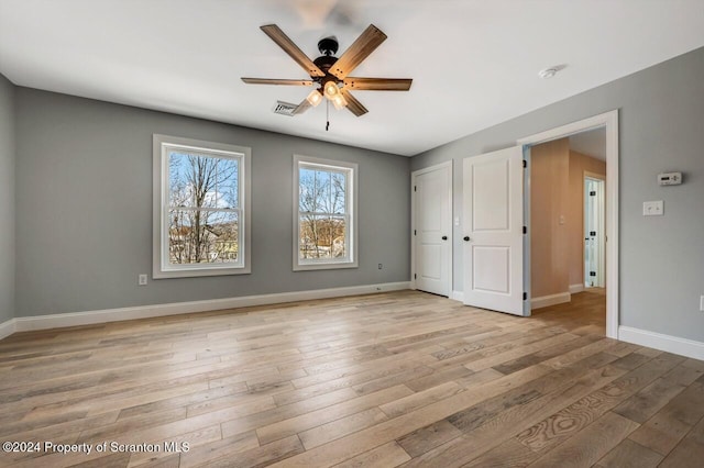 unfurnished bedroom featuring light wood finished floors, baseboards, visible vents, and a ceiling fan