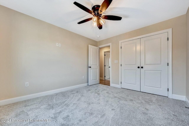 unfurnished bedroom featuring ceiling fan, light carpet, and a closet