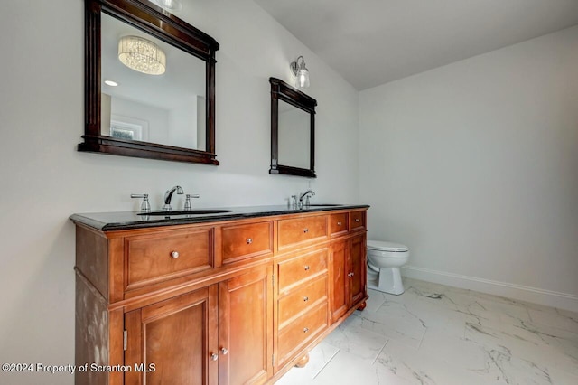 bathroom with marble finish floor, double vanity, a sink, and baseboards