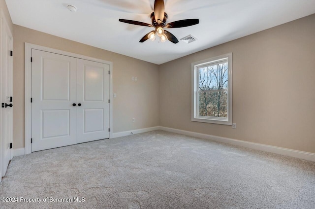 unfurnished bedroom with visible vents, baseboards, a ceiling fan, carpet, and a closet