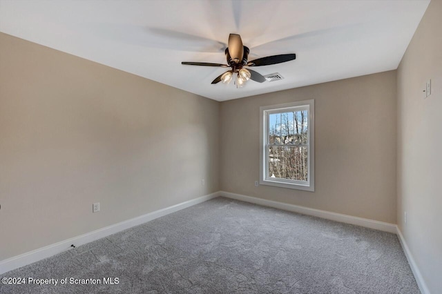 carpeted empty room featuring ceiling fan, visible vents, and baseboards