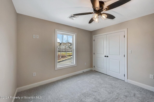 unfurnished bedroom featuring carpet flooring, a closet, and ceiling fan