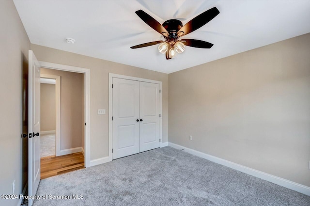 unfurnished bedroom with ceiling fan, a closet, carpet, and baseboards