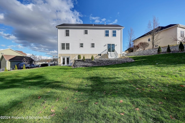 back of house featuring a yard and french doors