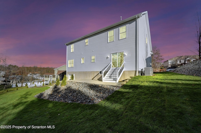 back of property with entry steps, a yard, and central air condition unit