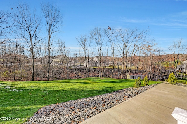 view of property's community featuring a lawn and an outdoor structure