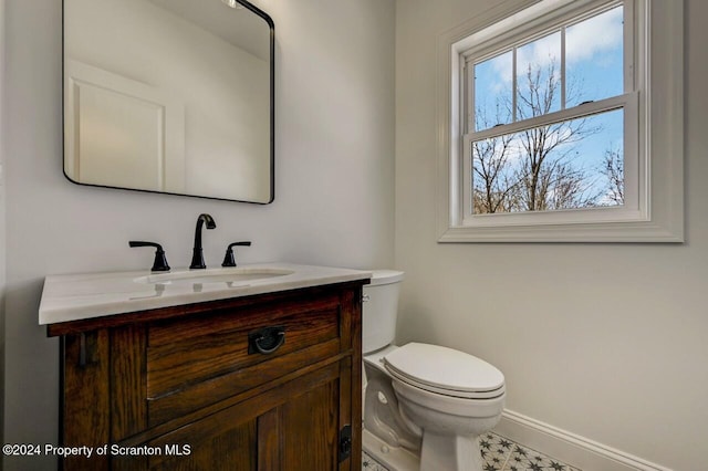 bathroom featuring baseboards, vanity, and toilet