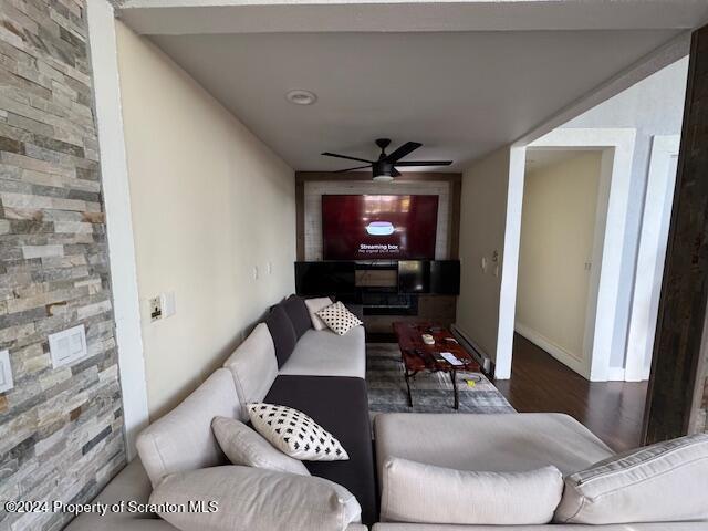 living room featuring dark hardwood / wood-style floors and ceiling fan