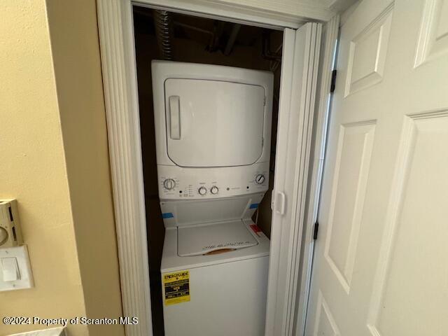 laundry area featuring stacked washer / drying machine