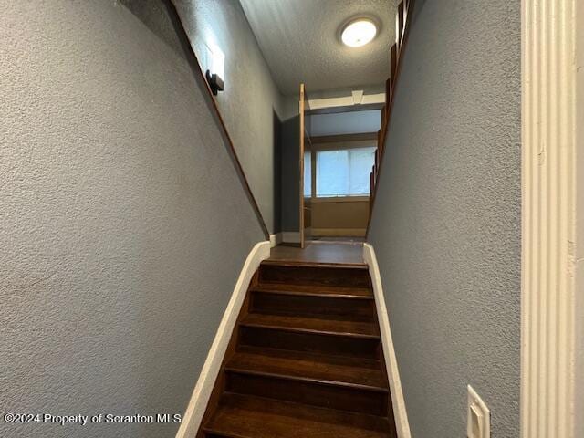 stairs featuring a textured ceiling