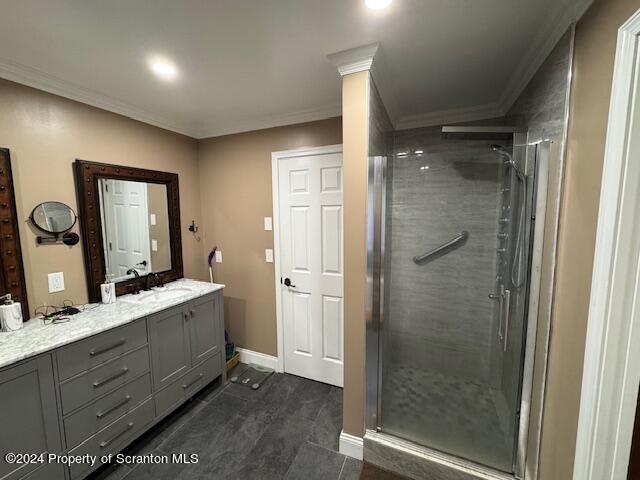 bathroom featuring crown molding, vanity, and walk in shower