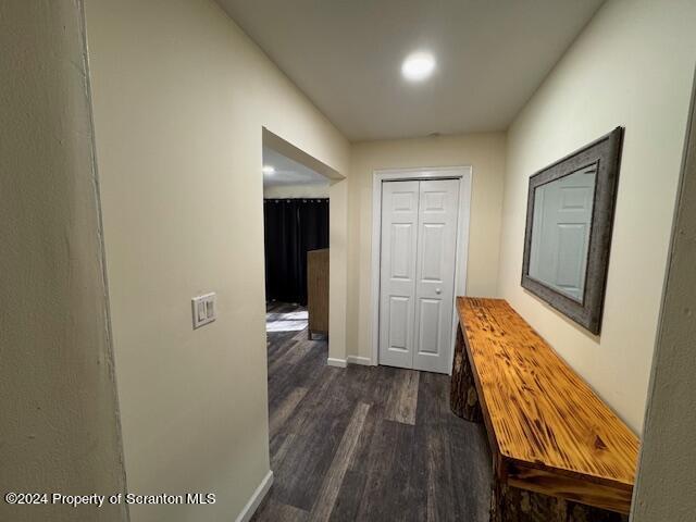 hallway with dark hardwood / wood-style flooring