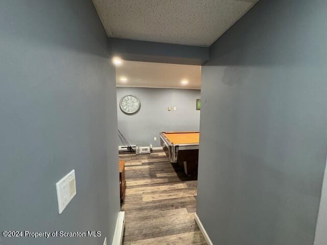 corridor with dark hardwood / wood-style floors and a baseboard radiator