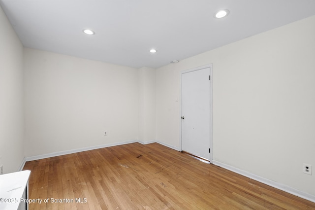 empty room with recessed lighting, baseboards, and light wood-type flooring