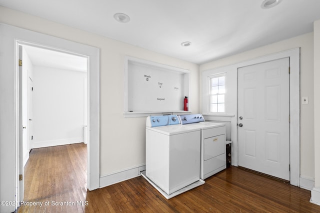 washroom with laundry area, dark wood finished floors, washing machine and dryer, and baseboards