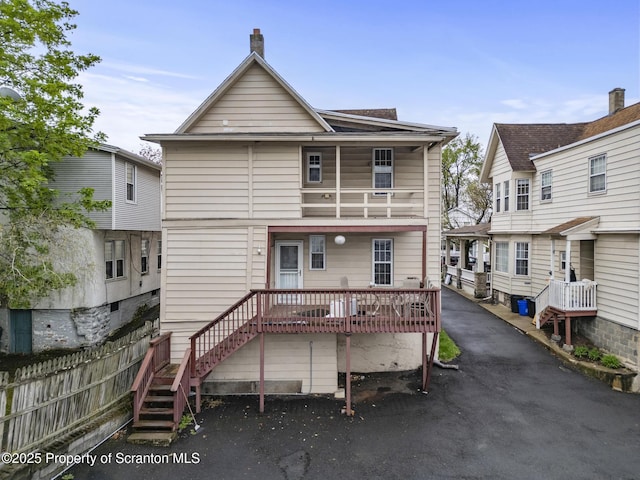 back of house featuring fence and stairway