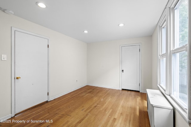 spare room featuring recessed lighting, baseboards, and light wood-type flooring