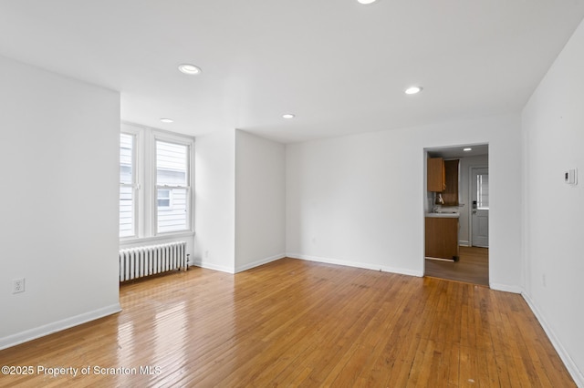 interior space featuring light wood-style floors, recessed lighting, baseboards, and radiator heating unit