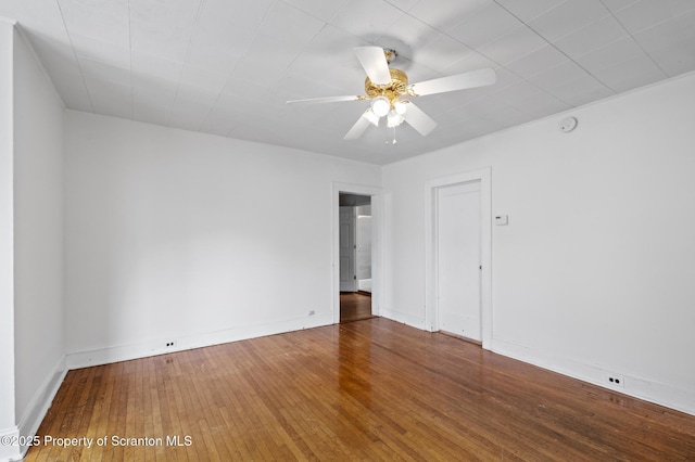 spare room featuring ceiling fan, baseboards, and hardwood / wood-style floors