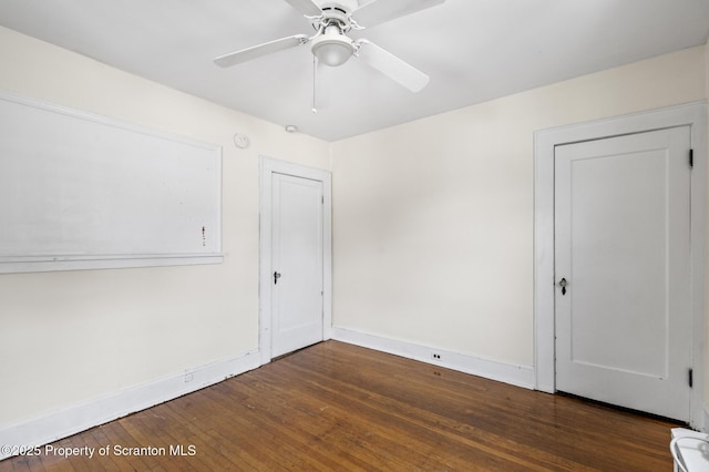 empty room featuring baseboards, wood-type flooring, and ceiling fan