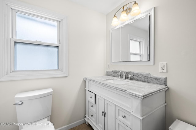bathroom featuring vanity, baseboards, and toilet