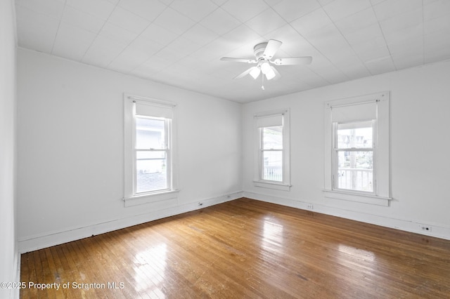 unfurnished room with baseboards, a ceiling fan, and hardwood / wood-style floors
