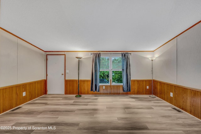 13 Hillside St Unit L 25, Nicholson, PA 18446 - unfurnished room featuring a wainscoted wall, wood walls, wood finished floors, and crown molding