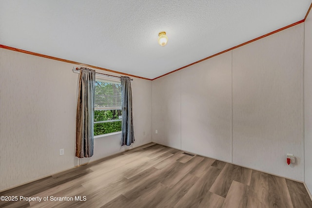 13 Hillside St Unit L 25, Nicholson, PA 18446 - empty room with wood finished floors, crown molding, and a textured ceiling