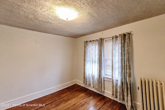 15 Leonard St, Wilkes-Barre, PA 18702 - spare room featuring radiator, dark wood-style floors, and a textured ceiling