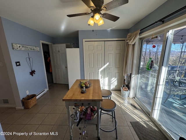 unfurnished dining area with tile patterned floors and ceiling fan