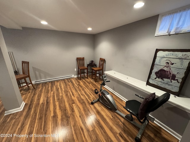 exercise room featuring dark hardwood / wood-style flooring and a baseboard radiator