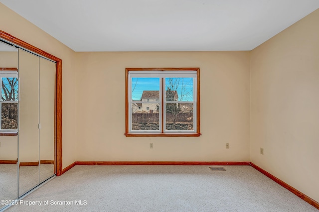 unfurnished bedroom with a closet, visible vents, and baseboards