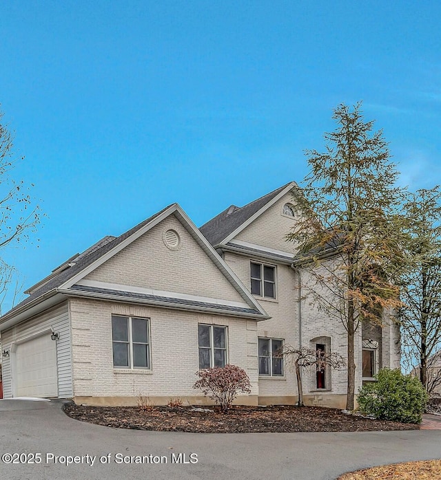 traditional home with brick siding and an attached garage