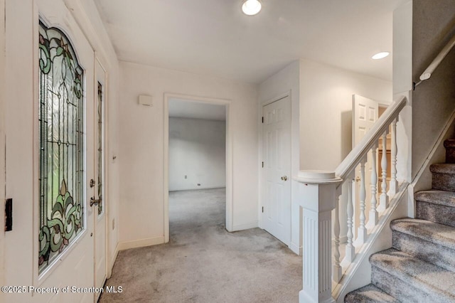 foyer entrance with recessed lighting, light carpet, baseboards, and stairs