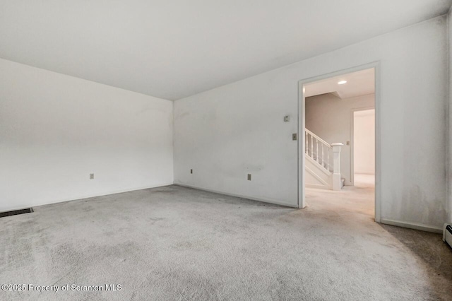 carpeted empty room with stairs and visible vents