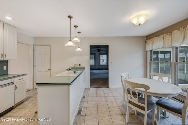 kitchen featuring a peninsula, light tile patterned floors, visible vents, and a sink