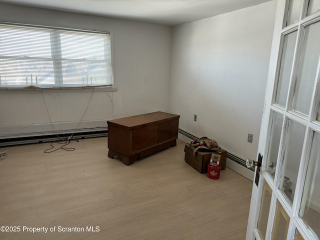 empty room featuring baseboard heating and light hardwood / wood-style floors