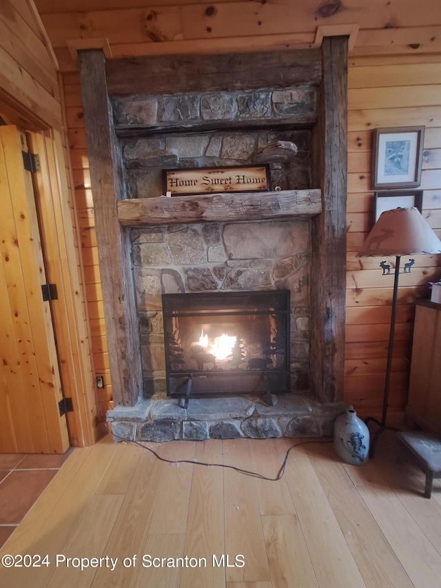 interior details with hardwood / wood-style floors, a fireplace, and wooden walls