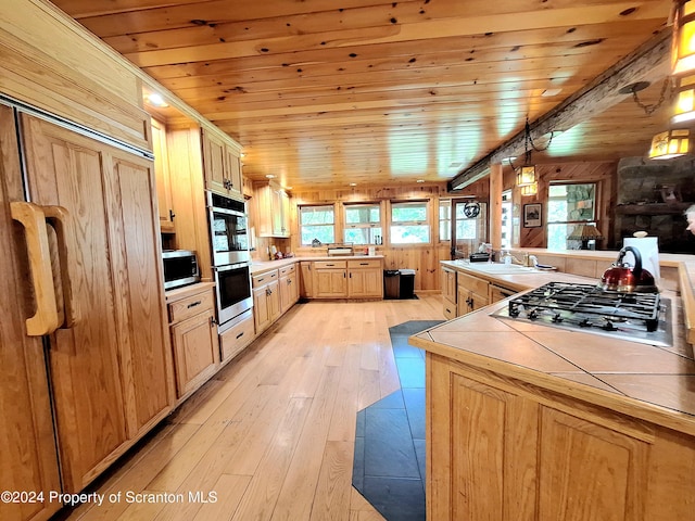 kitchen featuring tile countertops, light brown cabinetry, wood ceiling, and appliances with stainless steel finishes