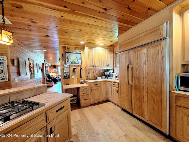 kitchen with wooden ceiling, hanging light fixtures, light hardwood / wood-style floors, light brown cabinetry, and appliances with stainless steel finishes