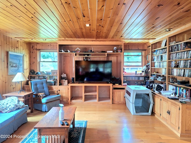 living room with wood walls, a healthy amount of sunlight, wooden ceiling, and light hardwood / wood-style floors