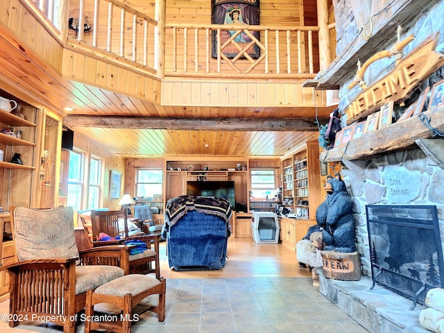 living room featuring built in shelves, a healthy amount of sunlight, and wood ceiling