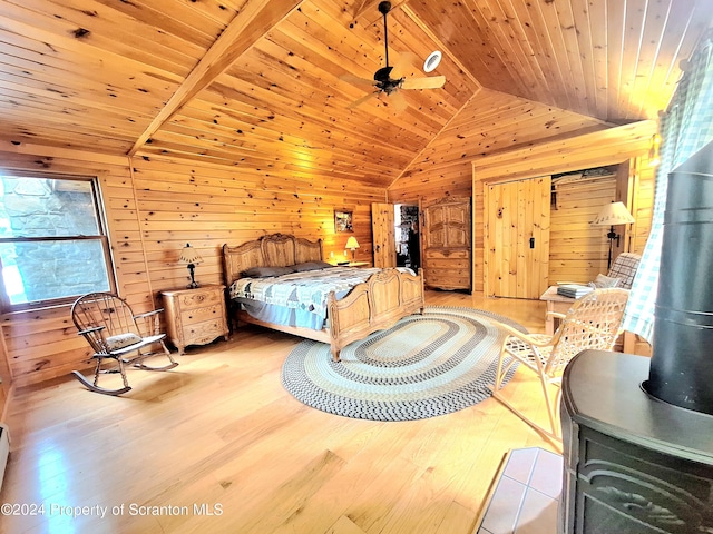 bedroom featuring lofted ceiling, wood walls, light wood-type flooring, and wooden ceiling