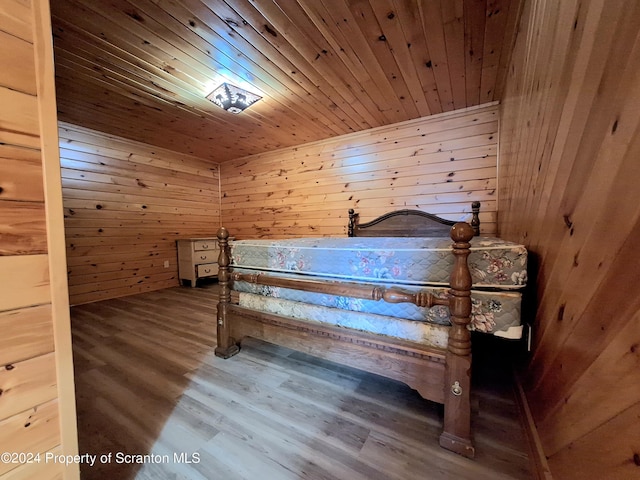 unfurnished bedroom featuring wood walls, wooden ceiling, and hardwood / wood-style flooring