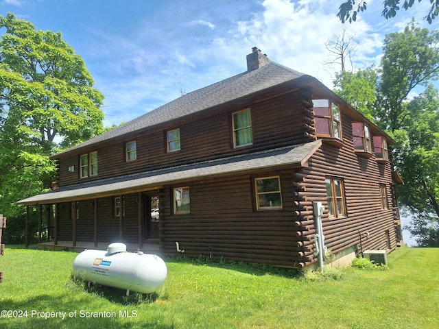 view of front of home featuring covered porch, central AC, and a front lawn